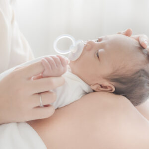 A beautiful Asian woman puts her newborn baby on her body